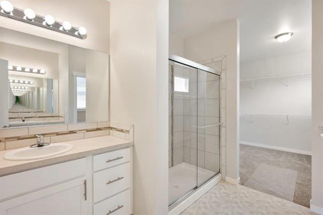 bathroom featuring a walk in closet, tasteful backsplash, a shower stall, vanity, and baseboards