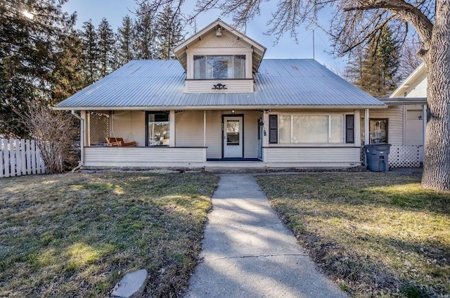 view of front of home featuring covered porch, metal roof, a front lawn, and fence