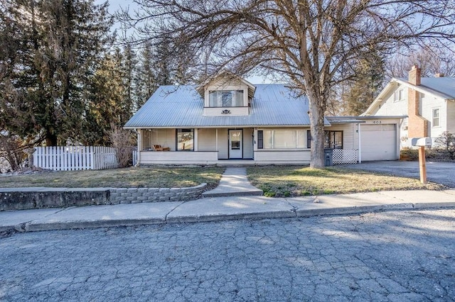 view of front of property with covered porch, fence, metal roof, a garage, and driveway