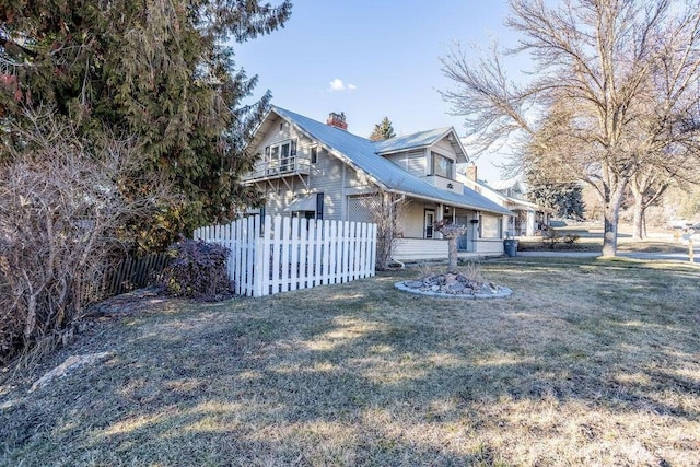 view of front of property with metal roof, fence, a chimney, and a front lawn