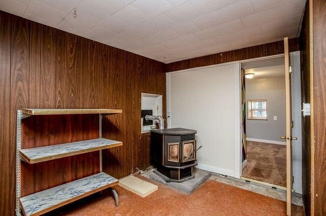 603 N Main St, Colville, WA 99114 - interior space featuring a wood stove and wood walls