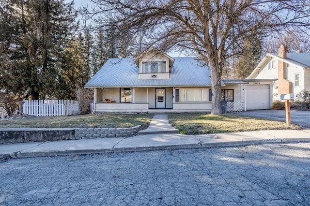 603 N Main St, Colville, WA 99114 - view of front of home featuring a garage, covered porch, metal roof, and asphalt driveway