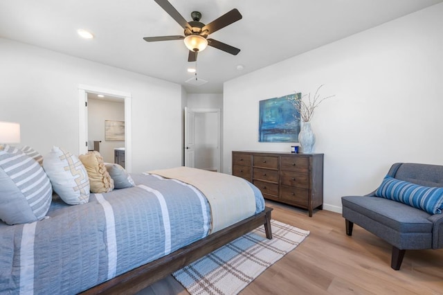 bedroom featuring light wood finished floors, recessed lighting, a ceiling fan, ensuite bath, and baseboards