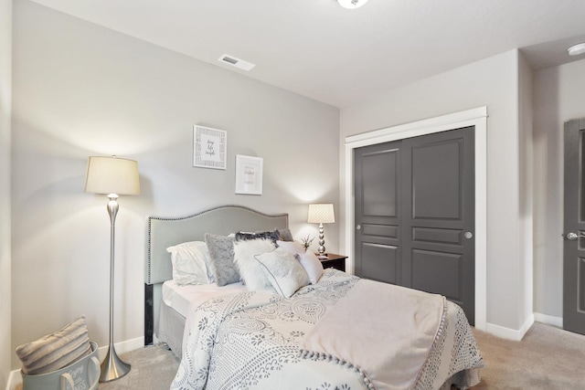 carpeted bedroom with a closet, visible vents, and baseboards