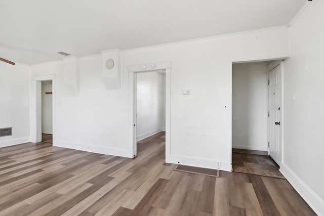 spare room featuring visible vents, baseboards, and wood finished floors