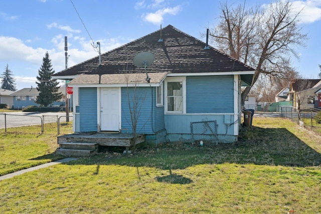 rear view of property with a yard and fence