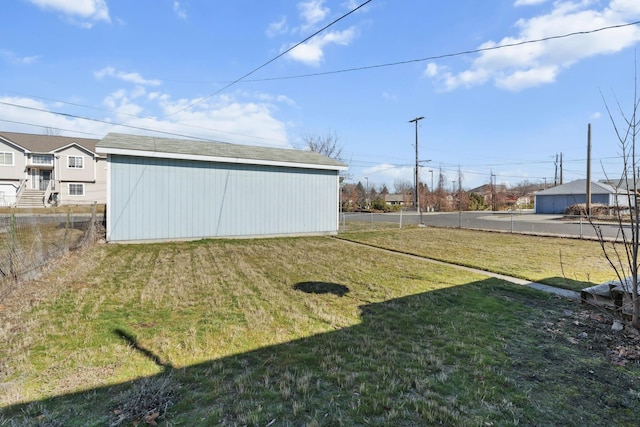 view of yard featuring fence, an outbuilding, and an outdoor structure