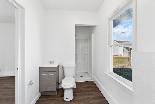 full bathroom featuring a shower, toilet, vanity, wood finished floors, and baseboards