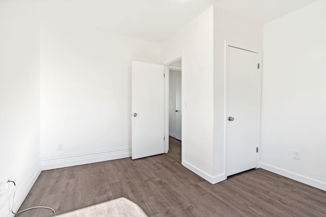 unfurnished bedroom with baseboards and wood finished floors