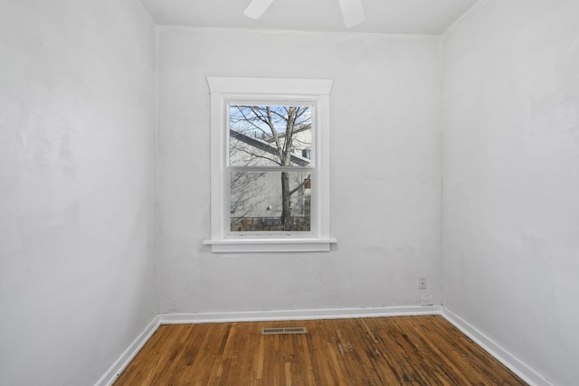 empty room with a ceiling fan, baseboards, visible vents, and hardwood / wood-style floors