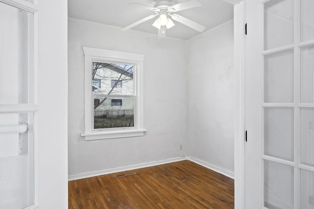 empty room featuring visible vents, ceiling fan, baseboards, and wood finished floors