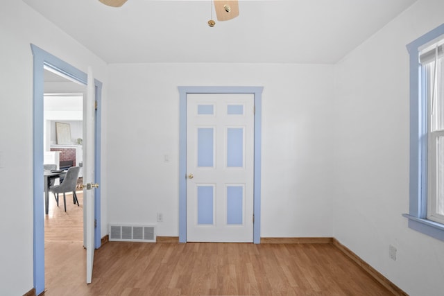 spare room with light wood-style floors, baseboards, and visible vents