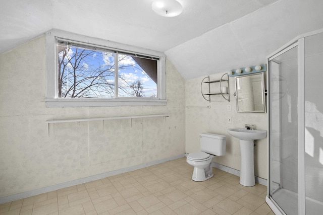 bathroom with lofted ceiling, toilet, a sink, baseboards, and a shower stall