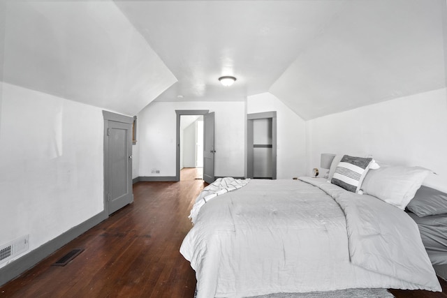 bedroom featuring lofted ceiling, wood finished floors, visible vents, and baseboards