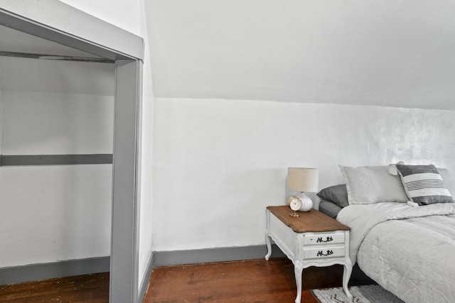 bedroom featuring a closet, vaulted ceiling, and wood finished floors