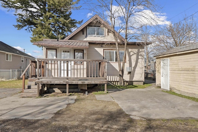 view of front of home featuring a patio area, fence, and metal roof