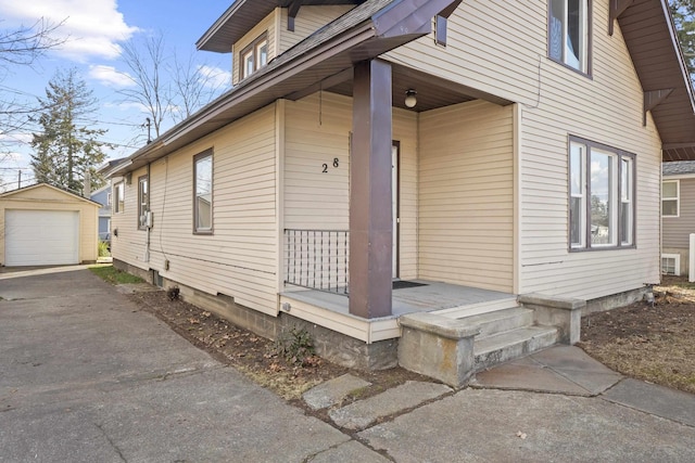 exterior space with covered porch, aphalt driveway, and a garage