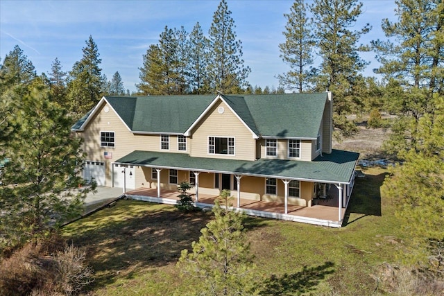 view of front facade with a garage, driveway, a porch, and a front yard