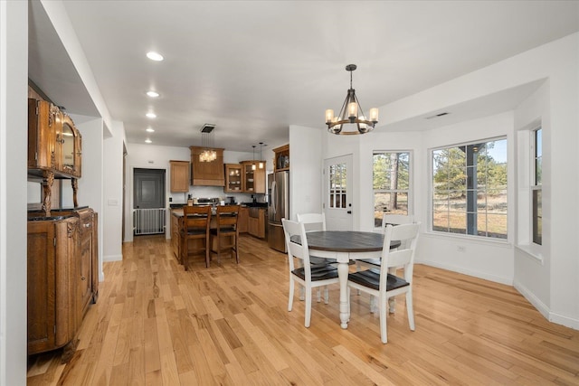 dining room with a chandelier, recessed lighting, light wood-type flooring, and baseboards