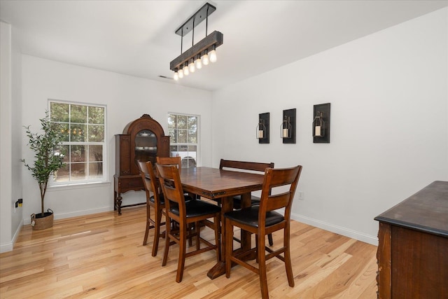 dining room featuring light wood-type flooring and baseboards