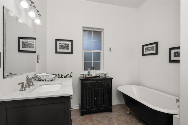 bathroom with a freestanding tub, vanity, and baseboards