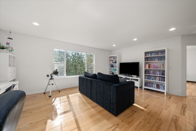 living room featuring baseboards, recessed lighting, and light wood-style floors