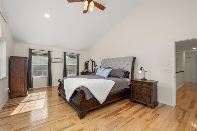 bedroom with lofted ceiling, light wood-style flooring, baseboards, and a ceiling fan