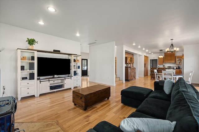 living area with light wood finished floors, recessed lighting, visible vents, a chandelier, and baseboards