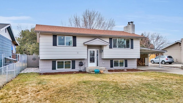 split foyer home featuring fence, driveway, a carport, a chimney, and a front yard