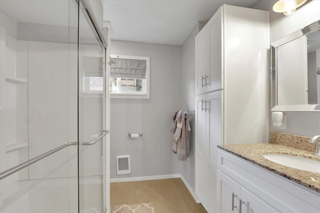 full bathroom featuring a stall shower, visible vents, vanity, and baseboards