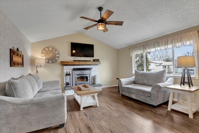 living room featuring lofted ceiling, ceiling fan, a textured ceiling, and wood finished floors