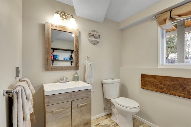 half bath with vanity, toilet, and baseboards