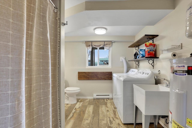 clothes washing area featuring gas water heater, a baseboard heating unit, laundry area, wood finished floors, and independent washer and dryer