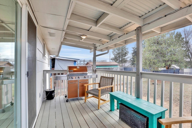 wooden deck featuring visible vents, fence, and area for grilling