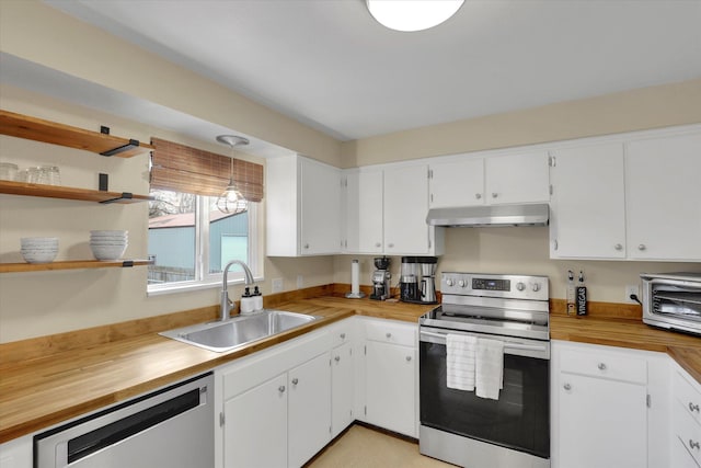 kitchen with under cabinet range hood, stainless steel appliances, a sink, wood counters, and open shelves