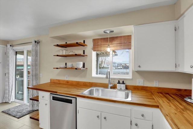 kitchen with a sink, white cabinets, wooden counters, and stainless steel dishwasher