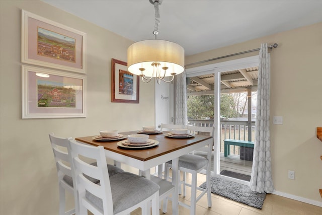 dining space featuring an inviting chandelier, baseboards, and tile patterned floors