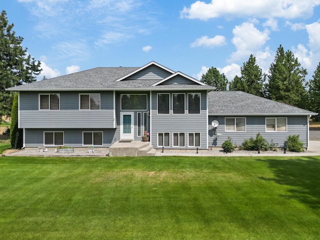 view of front of property with roof with shingles and a front yard