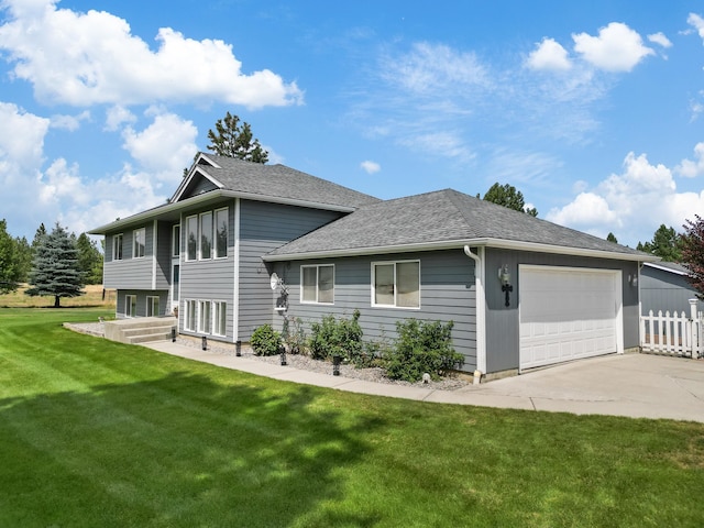 exterior space featuring a yard, roof with shingles, an attached garage, and driveway