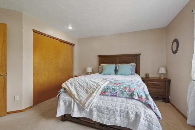 carpeted bedroom featuring baseboards, a closet, and recessed lighting