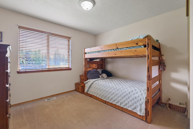 carpeted bedroom featuring visible vents and baseboards