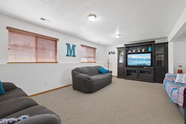 living room featuring carpet floors, baseboards, and visible vents