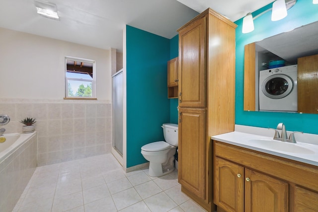 full bath with tiled bath, washer / clothes dryer, toilet, a stall shower, and tile patterned floors