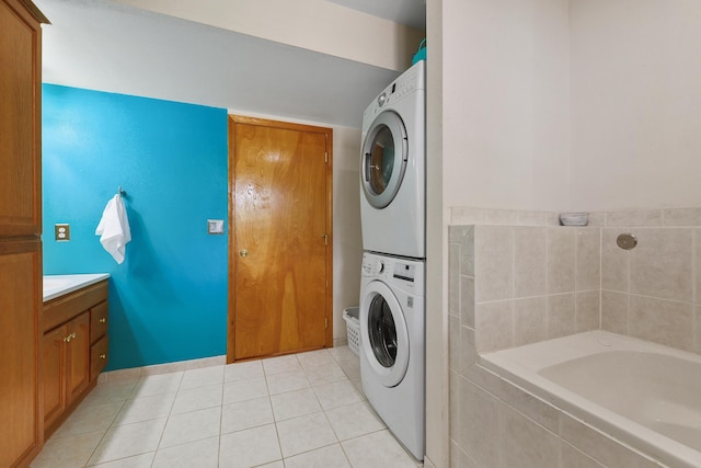 washroom with stacked washer and dryer, light tile patterned floors, and laundry area