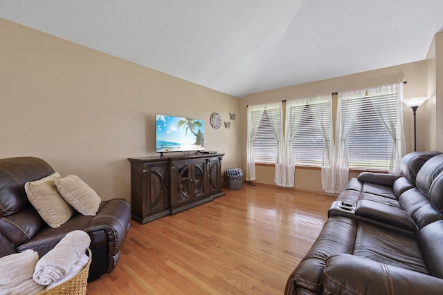 living area featuring lofted ceiling and light wood-style flooring