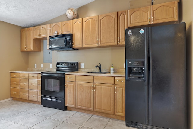 kitchen with light tile patterned floors, light countertops, vaulted ceiling, a sink, and black appliances