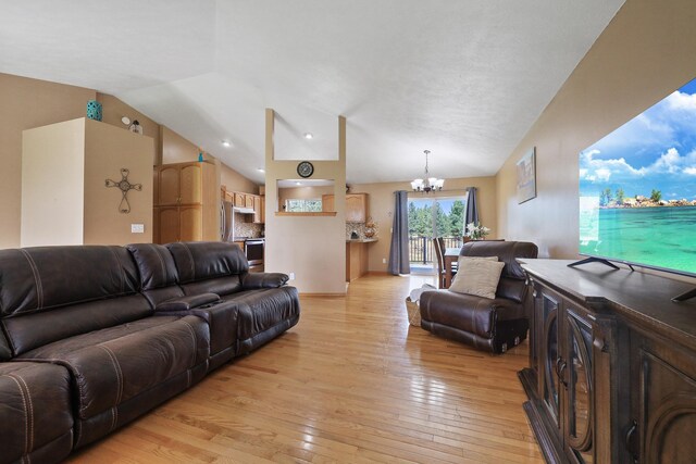 living room featuring lofted ceiling, light wood-type flooring, baseboards, and a notable chandelier