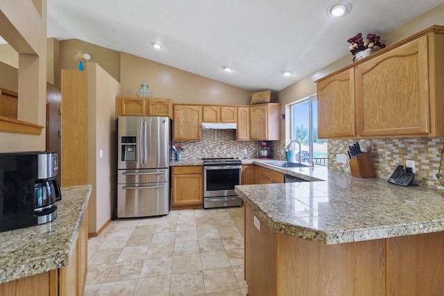 kitchen featuring a peninsula, vaulted ceiling, stainless steel appliances, under cabinet range hood, and a sink