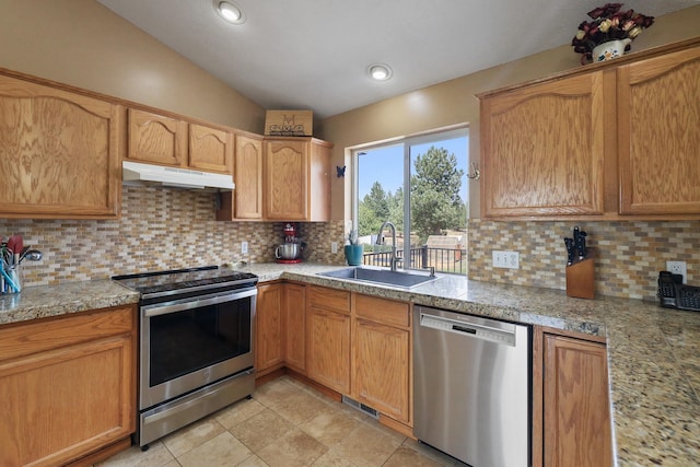 kitchen with recessed lighting, under cabinet range hood, a sink, appliances with stainless steel finishes, and tasteful backsplash