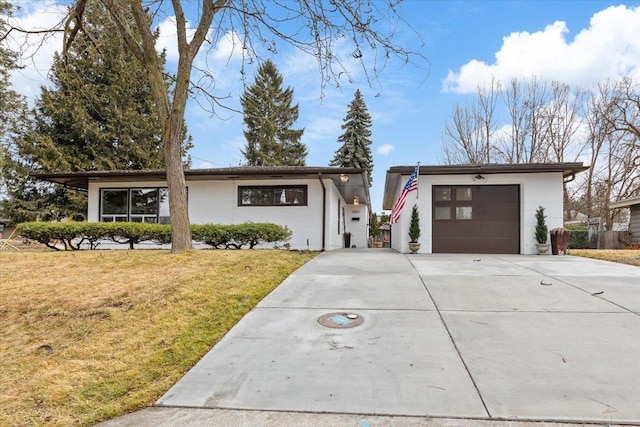 view of front facade featuring an attached garage, driveway, and a front lawn